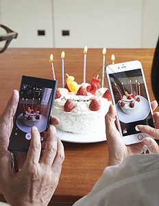 拿手机拍蛋糕的夫妻二人图片