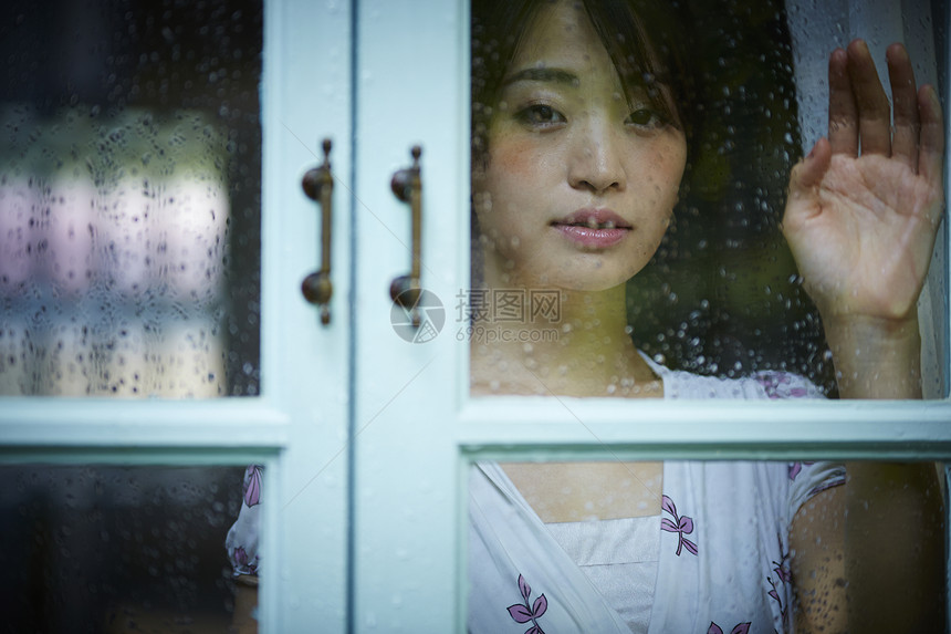 雨天女人在家里度过图片