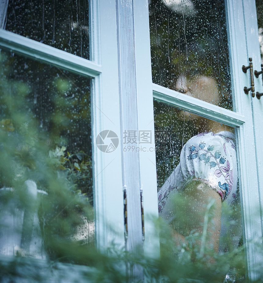 下雨天靠在窗边发呆的女性图片