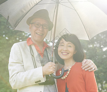 阳光明媚的打伞的老年情侣图片