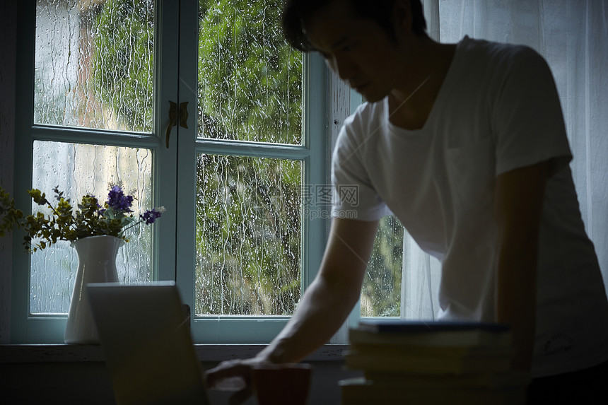 下雨天在室内的孤独男性图片