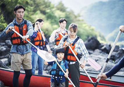 岸上穿着救生衣拿着划桨的家庭图片