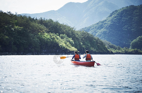 湖泊上穿着救生衣划独木舟的夫妇图片