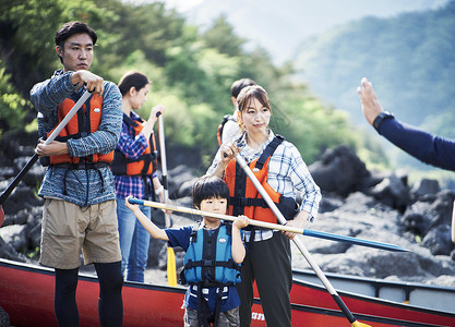 岸上穿着救生衣拿着划桨的一家人图片