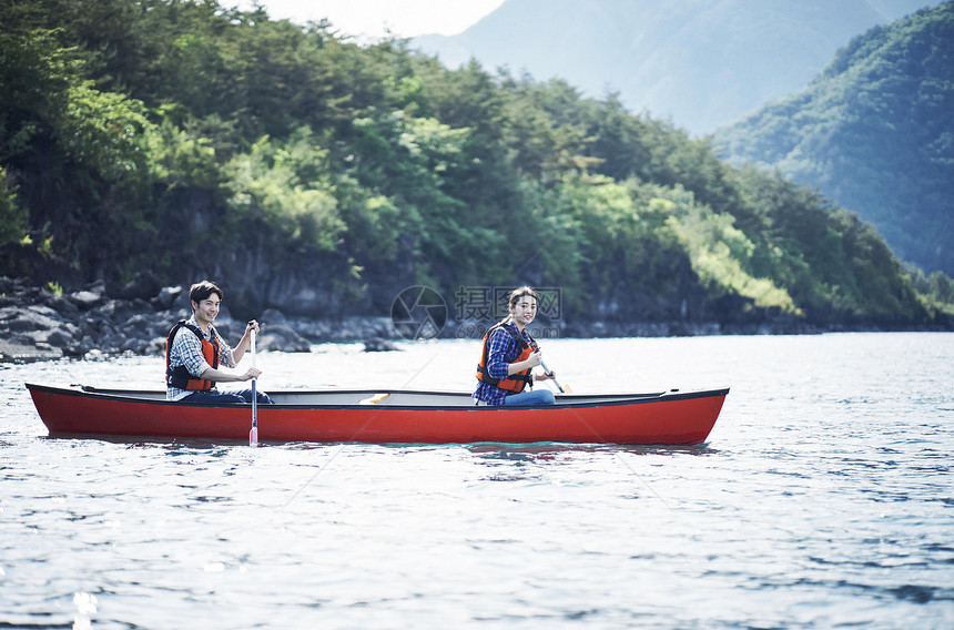 湖泊上划独木舟的夫妇图片