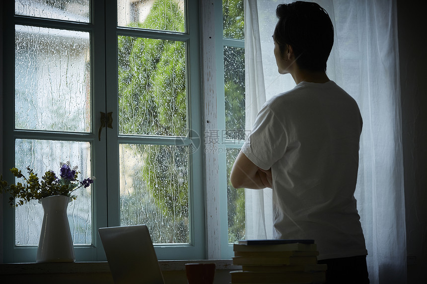 下雨天看着窗外的男性背影图片