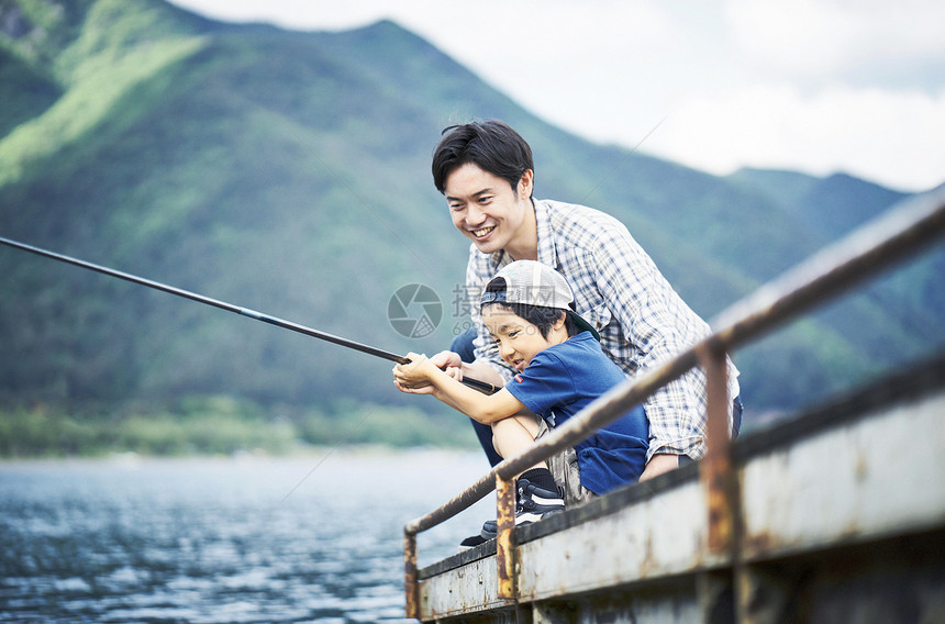 户外码头享受钓鱼的父子图片