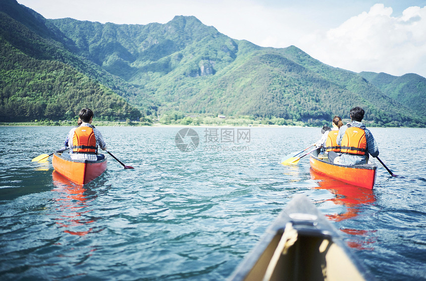 湖泊上划船观光的游客背影图片