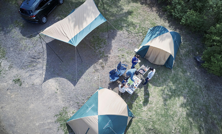 野外扎帐篷露营烧烤的家庭图片