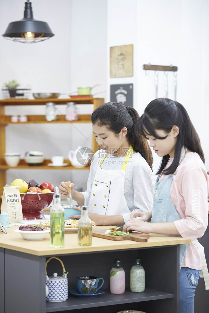 厨房里烹饪食物的青少年图片