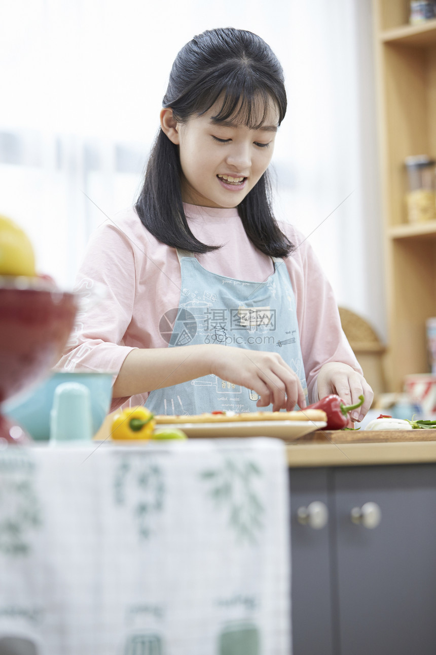 穿着围裙制作料理的小姑娘图片