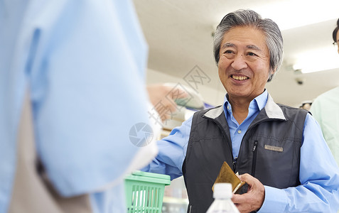 在便利店的收银台结账的老年顾客图片