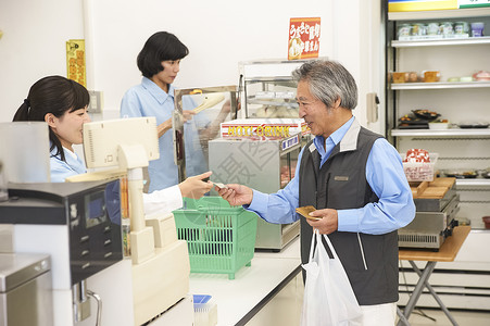 老年顾客在便利店的收银台结账图片