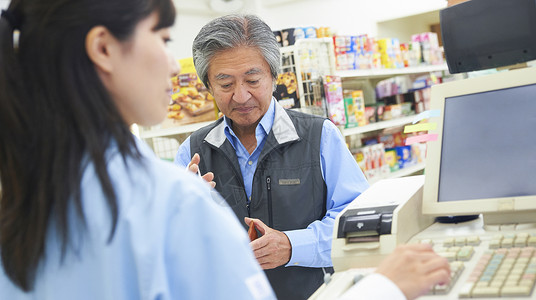 老年顾客在便利店的收银台结账图片