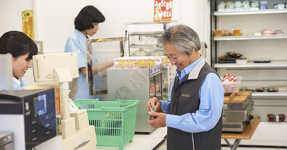 老年顾客在便利店的收银台结账图片