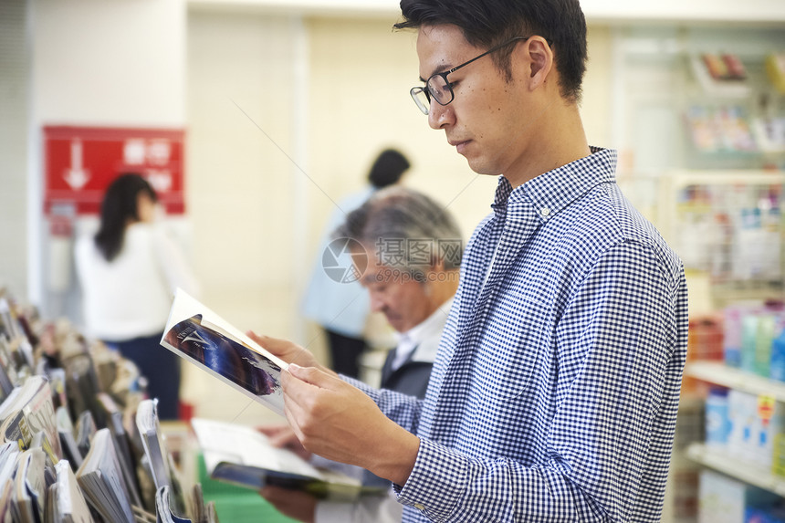 男子休息时间在便利店读书图片