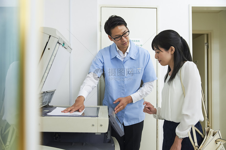 雇员教售货员在便利店使用复印机图片