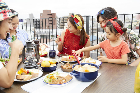 室外餐桌上用餐的一家人图片