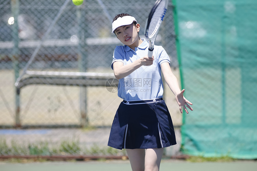 白天户外打网球的年轻女性图片