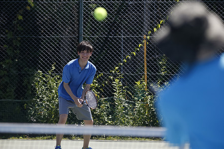 户外拿着球拍打网球的青年男性图片