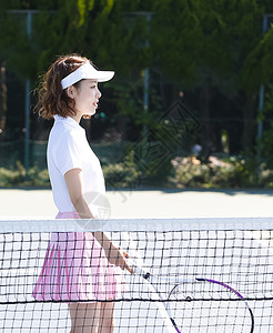 运动装努力获取演奏网球场的女人图片
