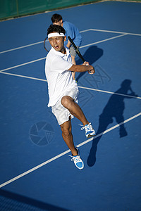 网球场上跳起的男青年图片