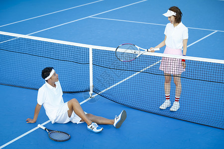 在网球场交谈的青年男女图片