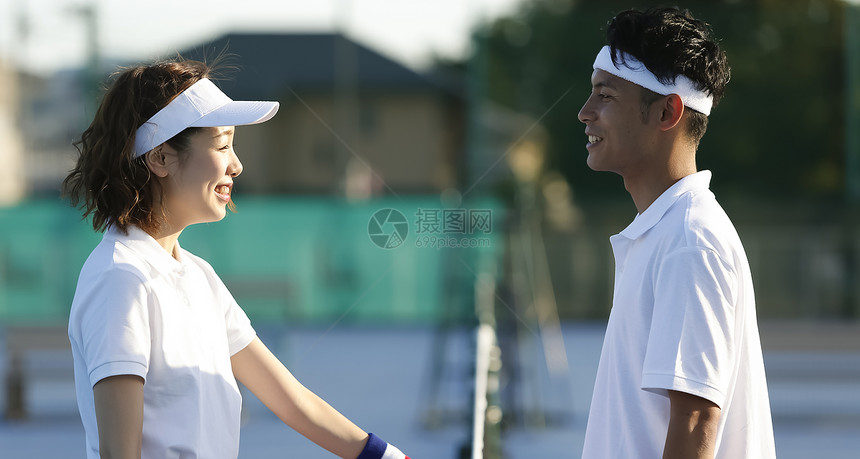 网球场上面对面微笑的男女青年图片
