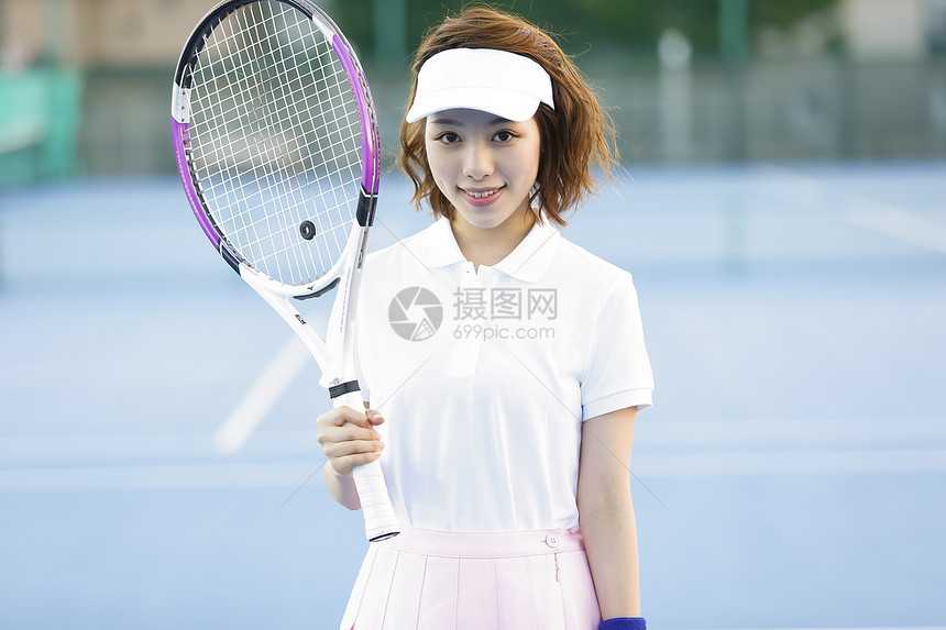 拿着网球拍微笑的网球少女图片