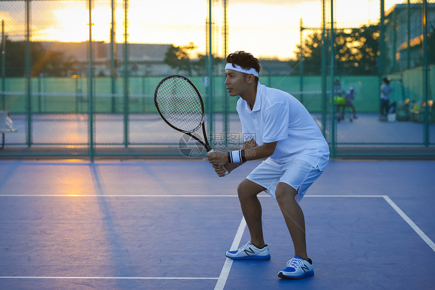 日落夕阳室外打网球的男性图片