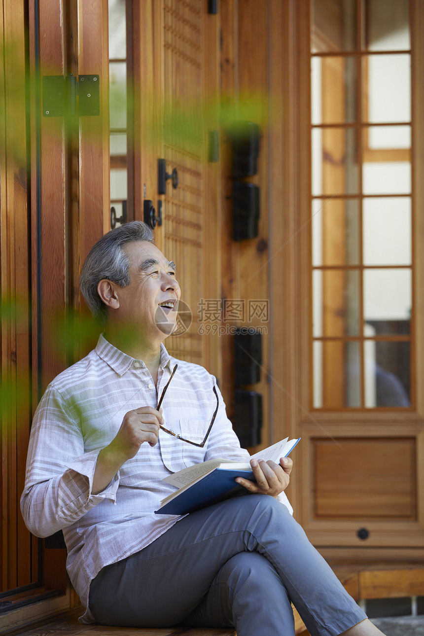 老年男性屋前阅读图片