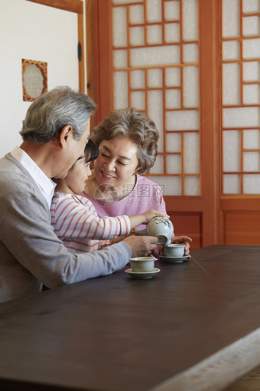 祖父祖母陪着孙女喝茶图片