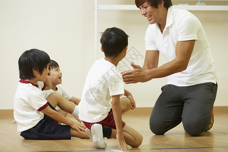 室内体育馆教学指导学生们运动的老师图片