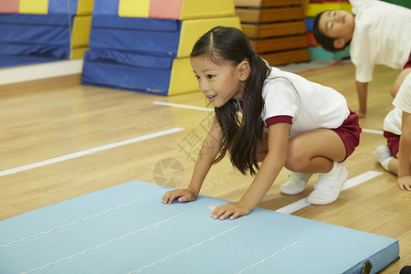 在垫子上运动练习的小女孩图片