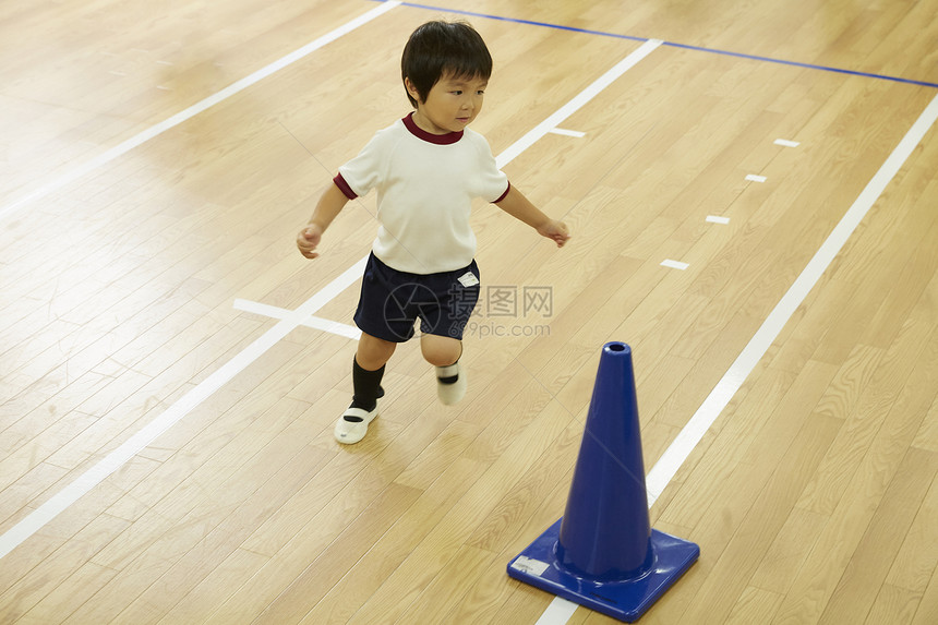 室内体育馆里奔跑的小男孩图片