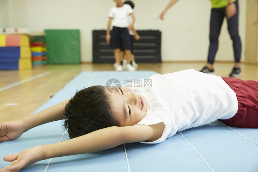 小男孩躺在垫子上休息图片