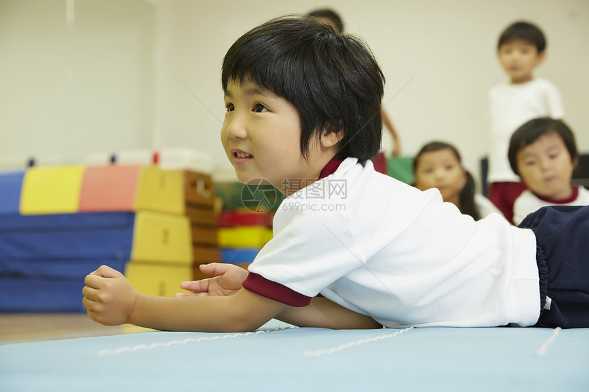 趴在垫子上的小男孩图片