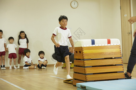 体操课堂练习跳箱的小男孩图片
