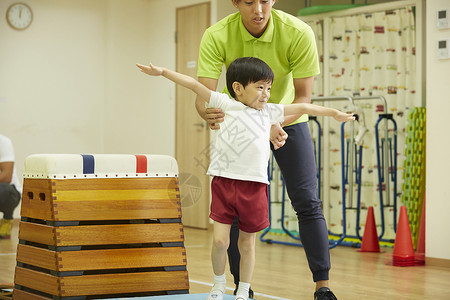 体操课堂练习跳箱落地的儿童图片