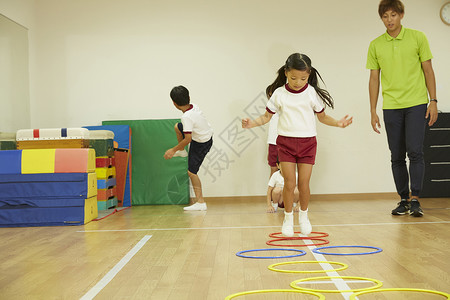 跳房子男孩小姑娘小孩教师体操教室跳跃背景