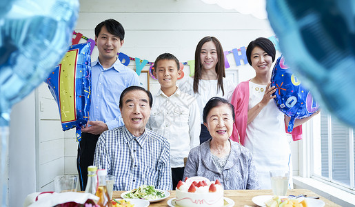 蛋糕男人和女人聚集三代家庭庆祝图片