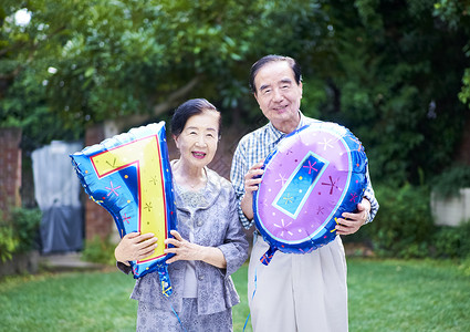 室外拿着气球庆祝节日的老夫妇图片