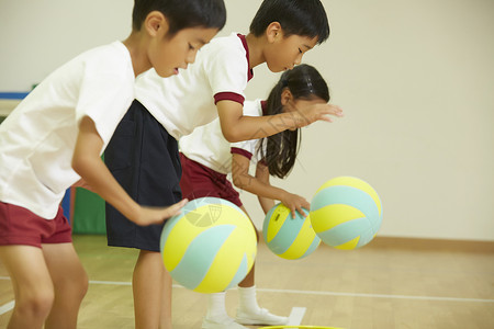 初等教育体育人物课外课程体操课孩子练习穿上球背景