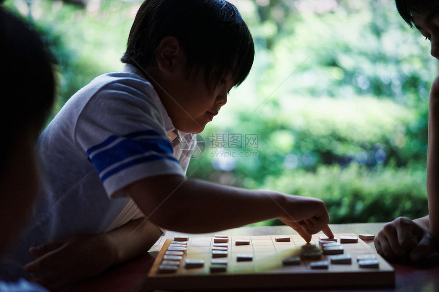 两个人沉思演奏指向shogi的男孩图片