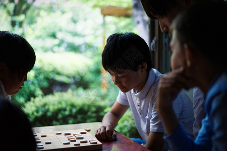 看着棋盘思考的男孩图片