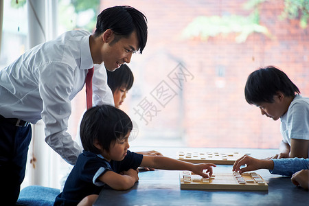 室内指导孩子们下棋的老师图片