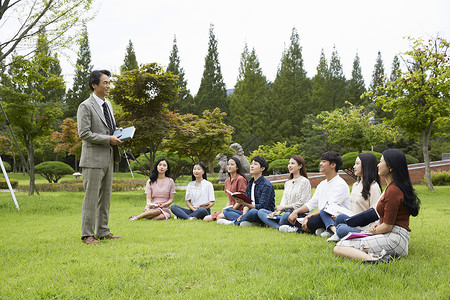 韩国校园素材大学校园草坪上放松的大学生背景