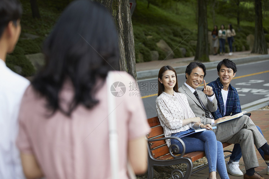 校园里坐在长椅上的老师和学生们图片