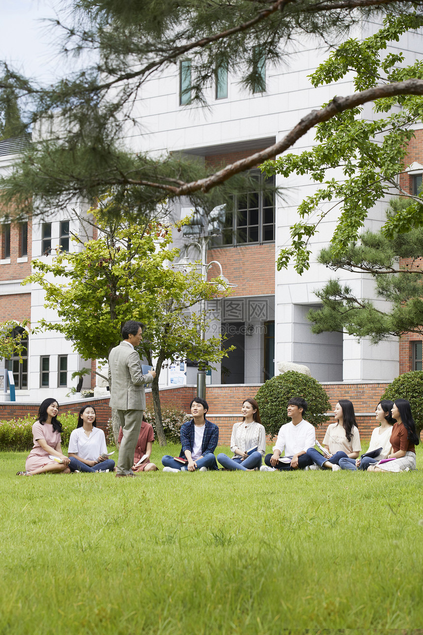 大学教授和学生们围坐在草地上分享交流图片