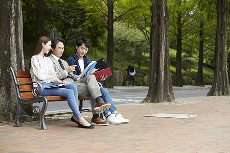 校园长凳上看书的教授和学生图片